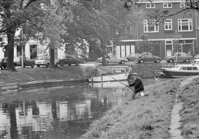 849233 Afbeelding van een vissende man aan de Stadsbuitengracht te Utrecht bij de Weerdsingel O.Z. Op de achtergrond ...